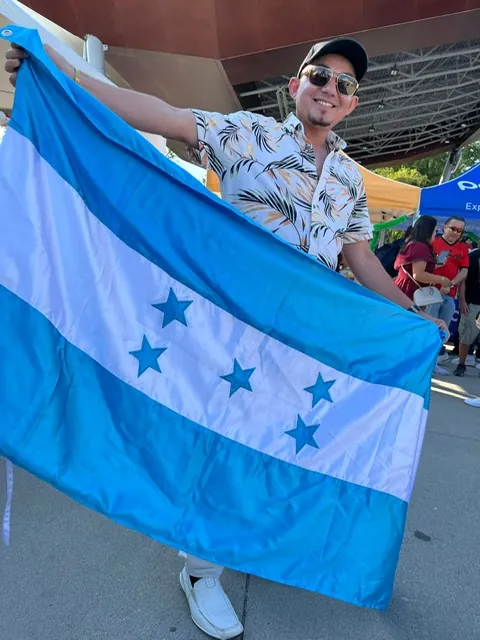 Honduran worker proudly holding the Honduras flag